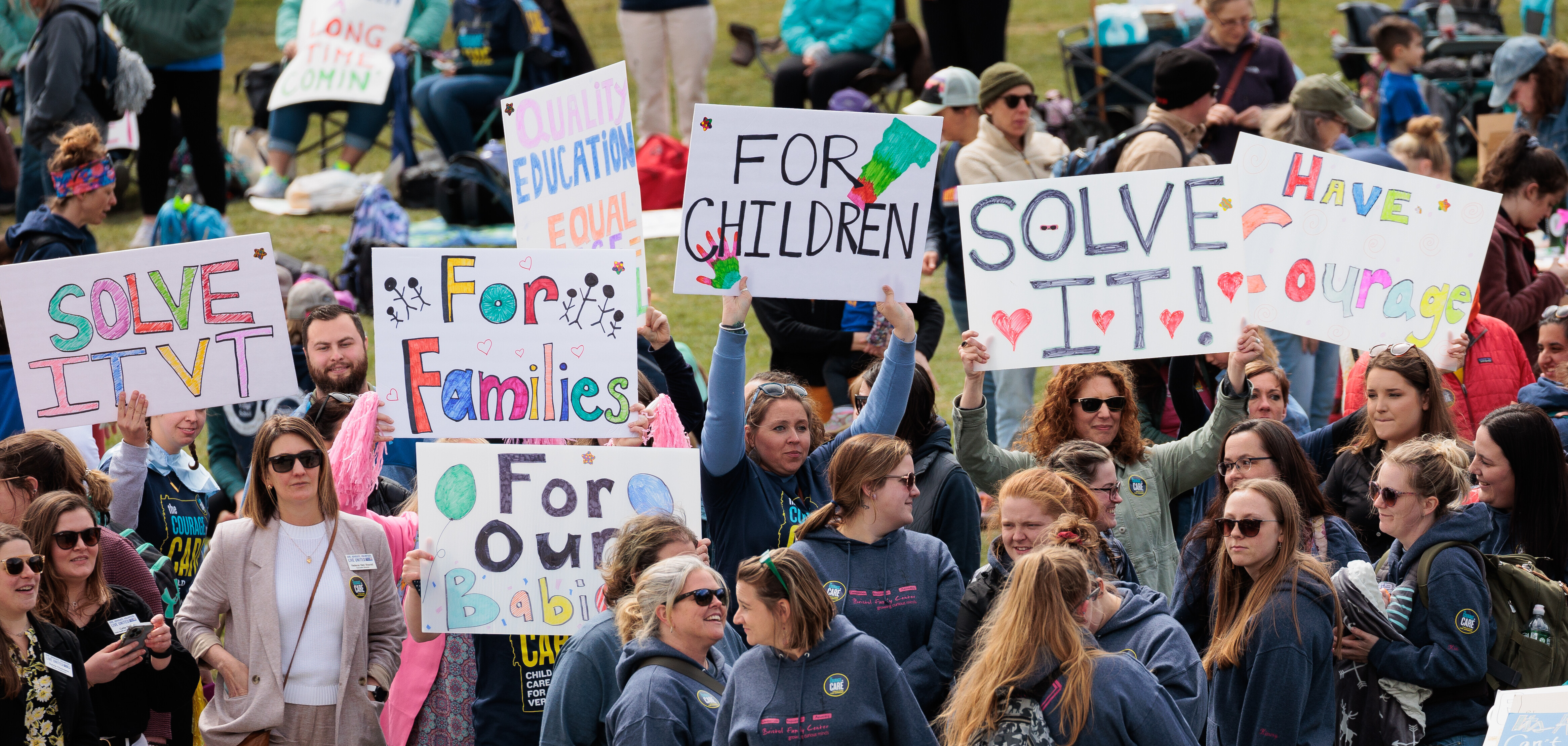 Rally-goers hold up signs to show support for the Vermont's Child Care Bill.